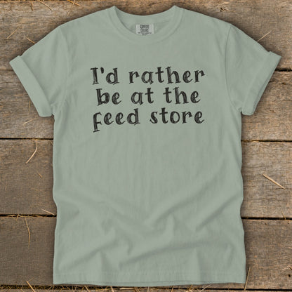 Light green Comfort Colors t-shirt with "I'd rather be at the feed store" text.