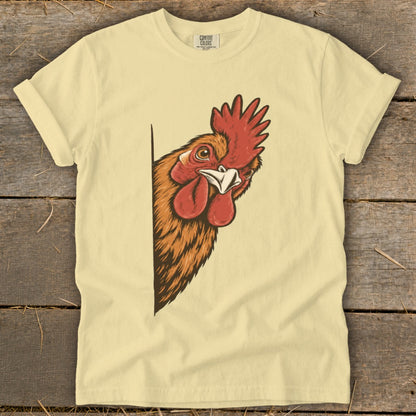 Rooster peeking from the side on a light yellow t-shirt.