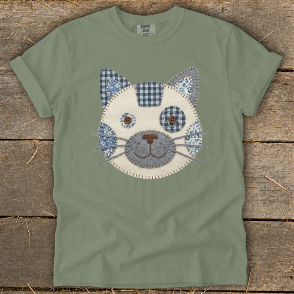 Sage green t-shirt with a stitched cat face applique.
