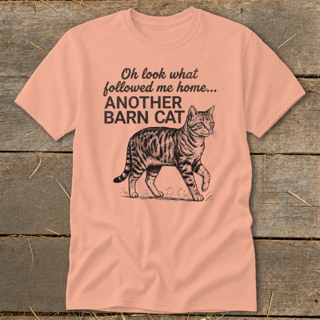 Peach t-shirt with text "Oh look what followed me home... ANOTHER BARN CAT" and a tabby cat graphic.