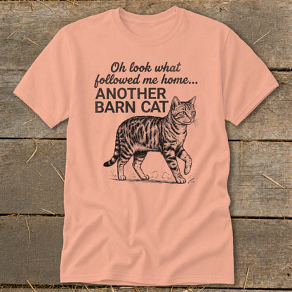 Peach t-shirt with text "Oh look what followed me home... ANOTHER BARN CAT" and a tabby cat graphic.