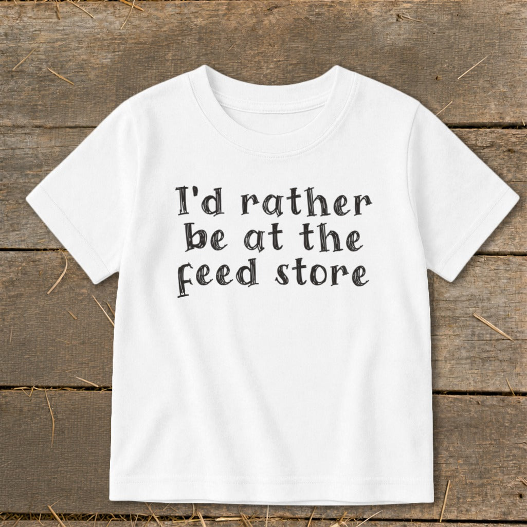 White t-shirt with black text that reads "I'd rather be at the feed store".