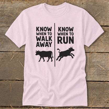 Pink t-shirt with text "Know When To Walk Away" and "Know When To Run" and cow graphics.