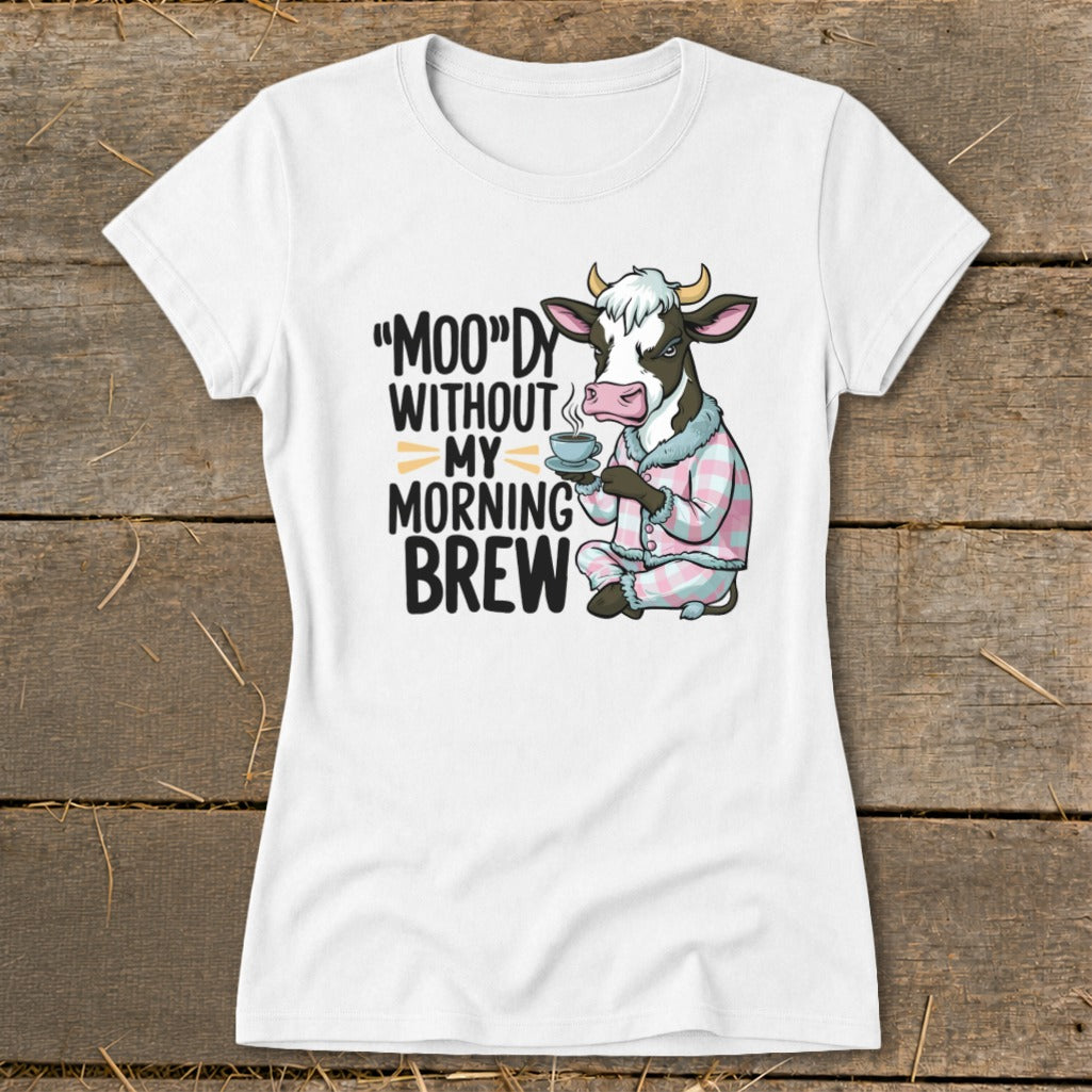 White t-shirt with cow in pajamas holding coffee, text "Moo'dy Without My Morning Brew."