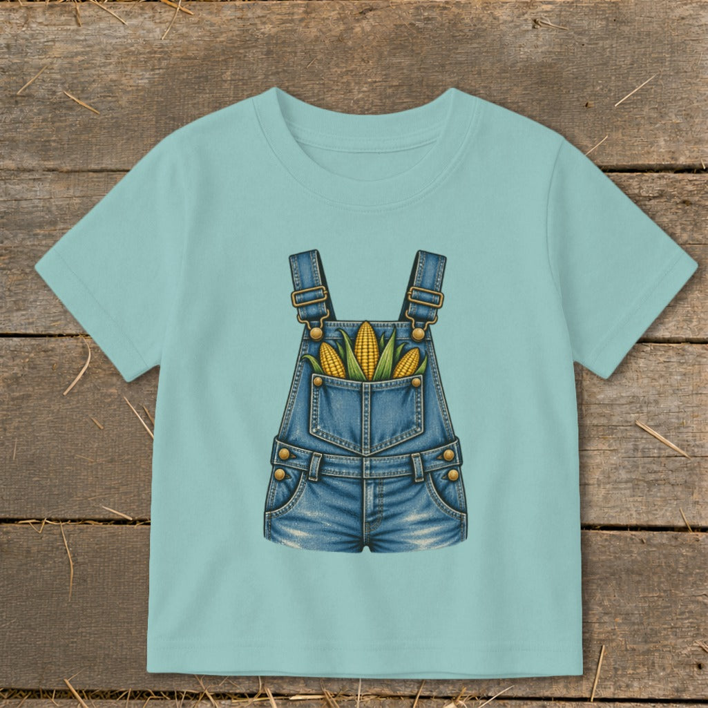Light blue t-shirt with a denim overalls graphic holding corn on the cob.
