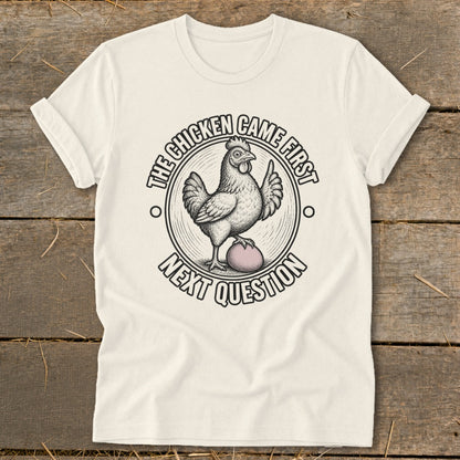 Cream t-shirt with chicken and egg graphic, text "The Chicken Came First Next Question".