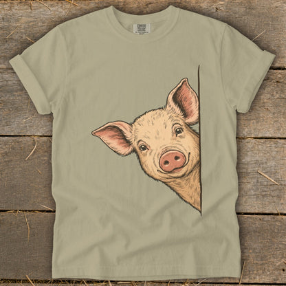 T-shirt with a drawing of a cute pig peeking around a corner.