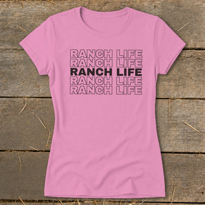 A short-sleeved pink t-shirt with five rows of stacked black text reading RANCH LIFE.