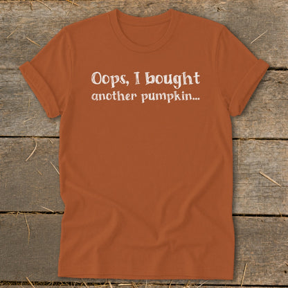 Orange t-shirt with white text reading "Oops, I bought another pumpkin...".