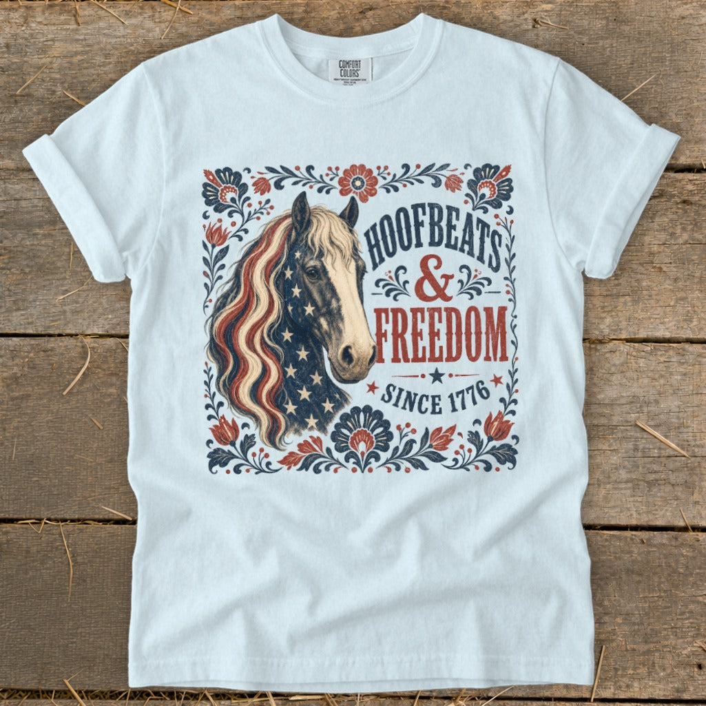 White t-shirt with horse graphic and text "Hoofbeats & Freedom Since 1776."