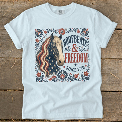 White t-shirt with horse graphic and text "Hoofbeats & Freedom Since 1776."
