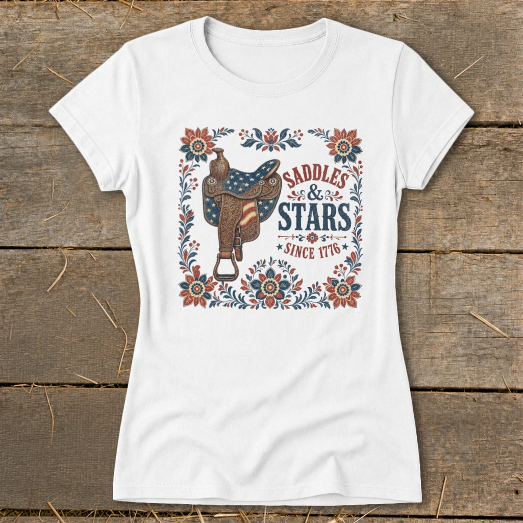 White t-shirt with "Saddles & Stars Since 1776" text and patriotic saddle graphic.