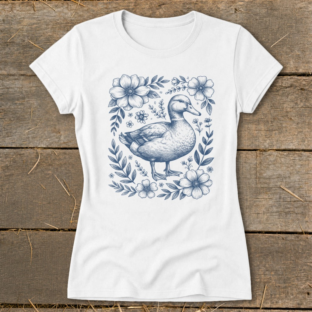 White t-shirt with a blue line drawing of a duck surrounded by flowers and leaves.