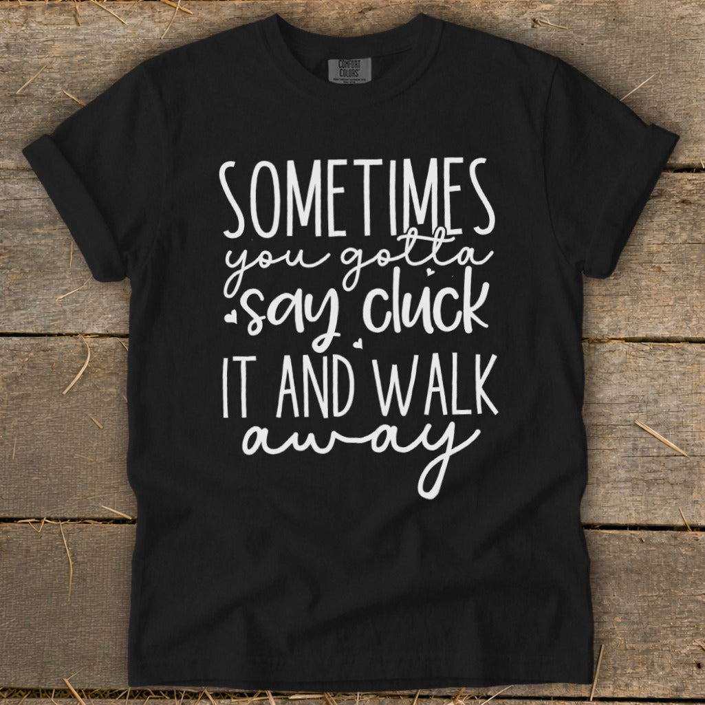 Black t-shirt with white text "Sometimes you gotta say cluck it and walk away".