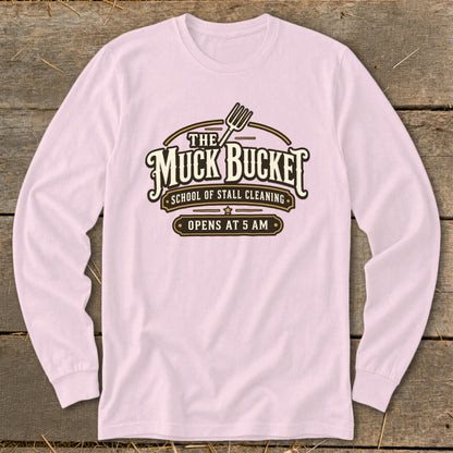 Pink long-sleeved shirt with "The Muck Bucket School of Stall Cleaning" logo.