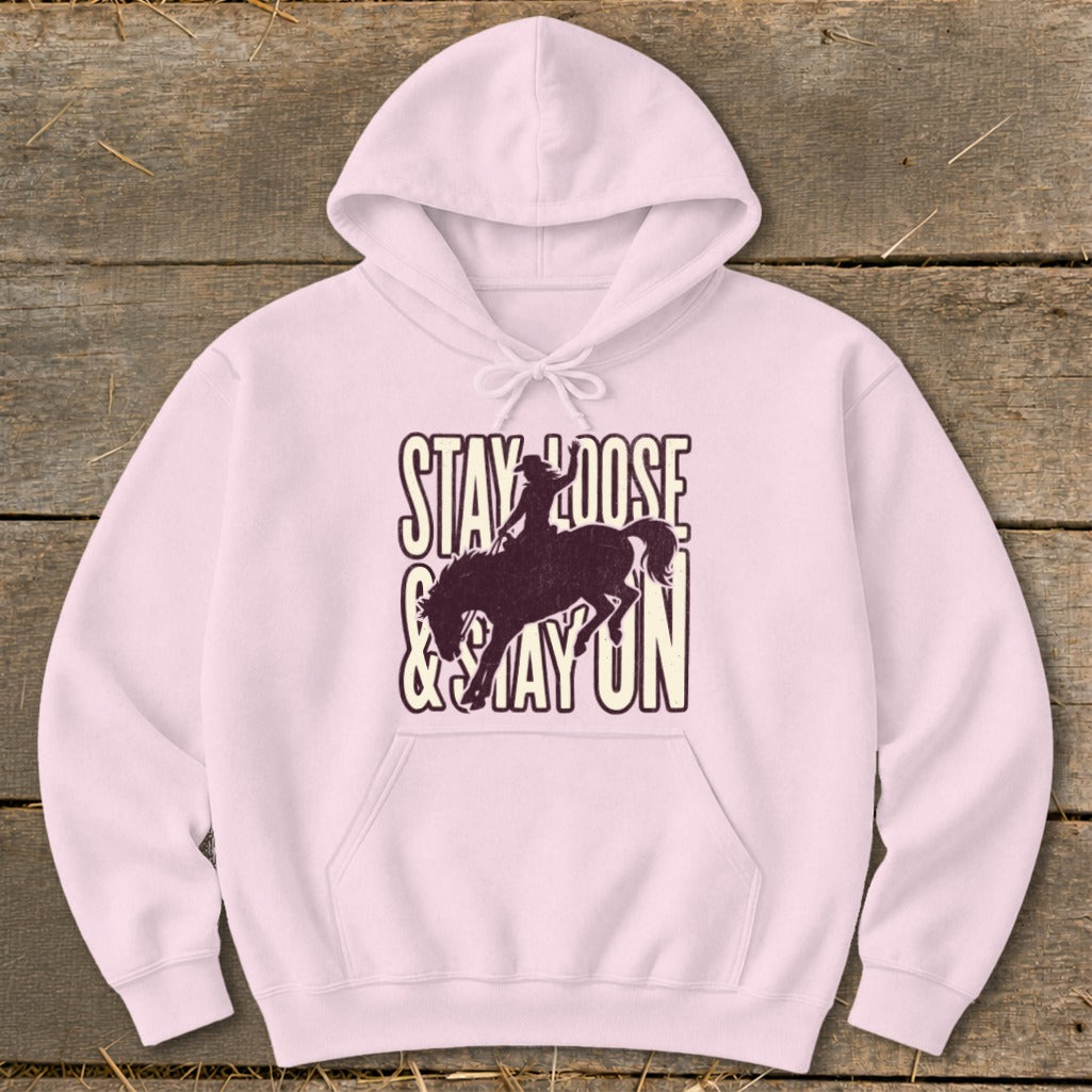 Pink hoodie with "Stay Loose & Stay On" text and bucking bronco silhouette.