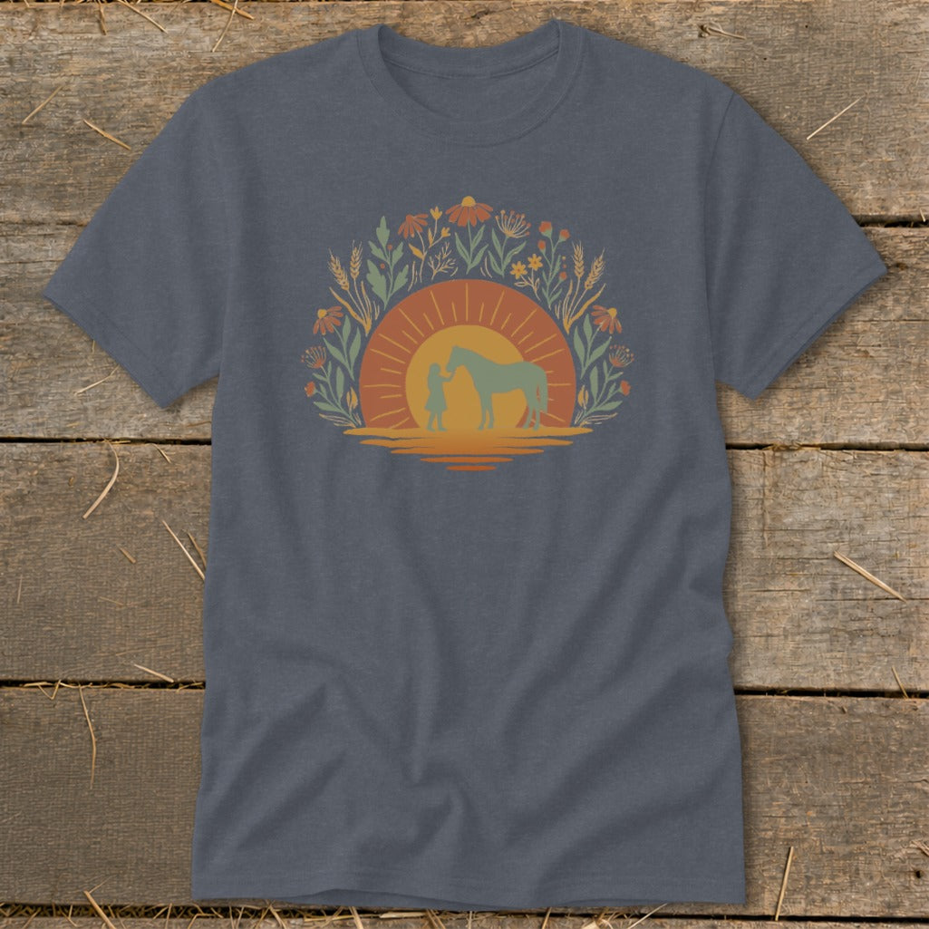 T-shirt with graphic of girl and horse against sunset surrounded by flowers and wheat.
