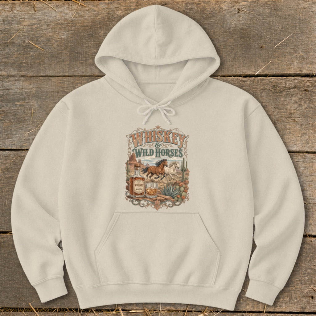 Cream hoodie with Whiskey & Wild Horses graphic featuring horses, desert, and whiskey bottle.