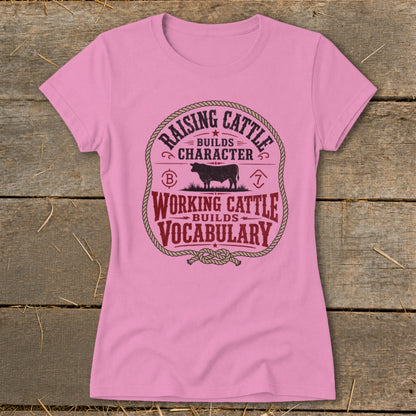 Pink t-shirt with "Raising Cattle Builds Character" and "Working Cattle Builds Vocabulary" text and cow graphic.