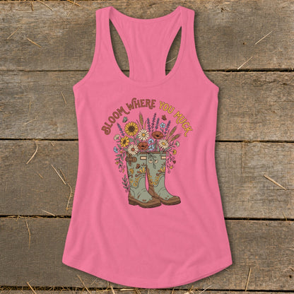 Pink tank top with graphic of boots overflowing with flowers and the text "Bloom Where You Muck".