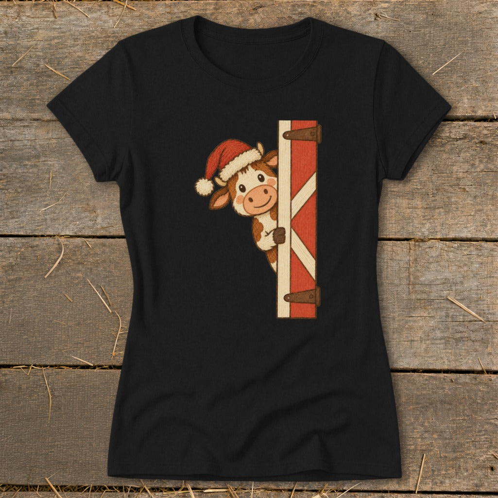 Black t-shirt with a cartoon cow wearing a Santa hat peeking from behind a barn door.