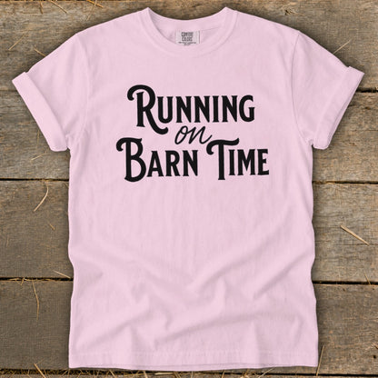 Pink t-shirt with black text that reads "Running on Barn Time".