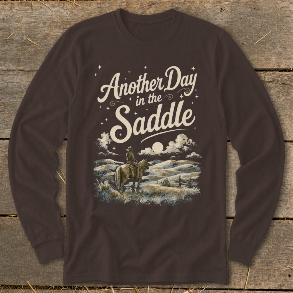 Long-sleeve brown t-shirt with "Another Day in the Saddle" and cowboy on horseback graphic.