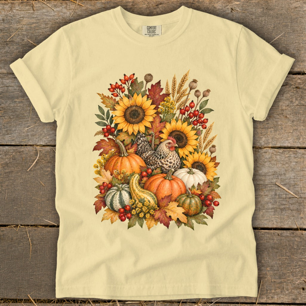 Yellow t-shirt with a watercolor fall arrangement of sunflowers, pumpkins, gourds, and a chicken.
