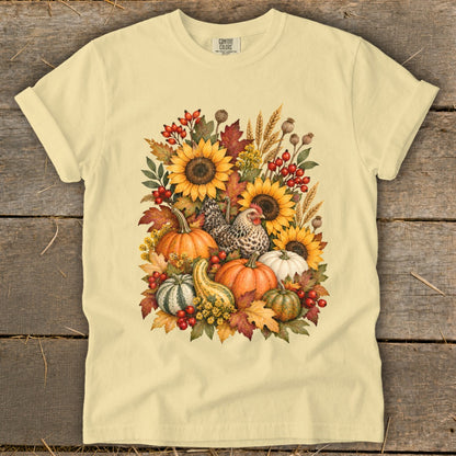 Yellow t-shirt with a watercolor fall arrangement of sunflowers, pumpkins, gourds, and a chicken.