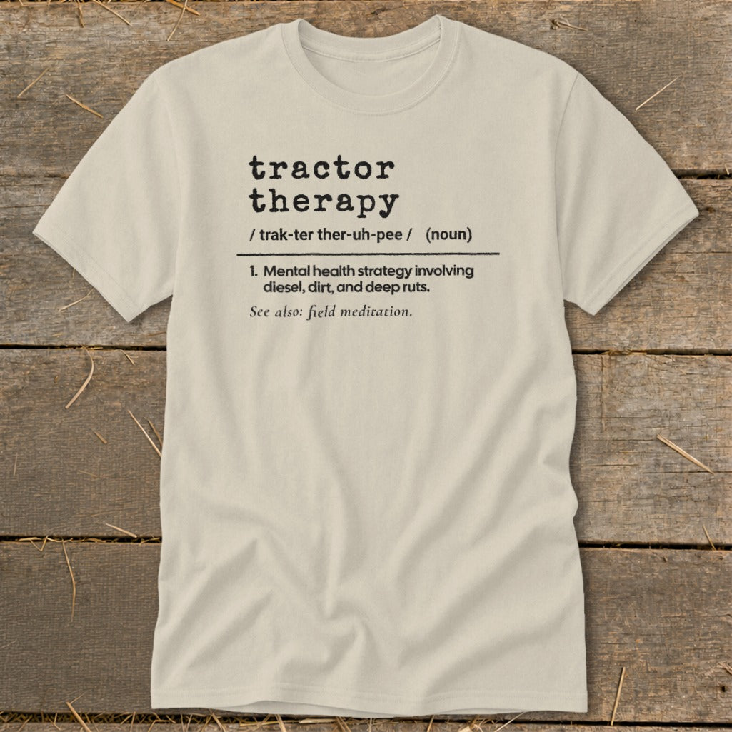 Tractor therapy definition on a light tan t-shirt.