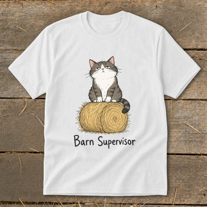 White t-shirt with a cartoon cat sitting on a bale of hay, text says "Barn Supervisor".