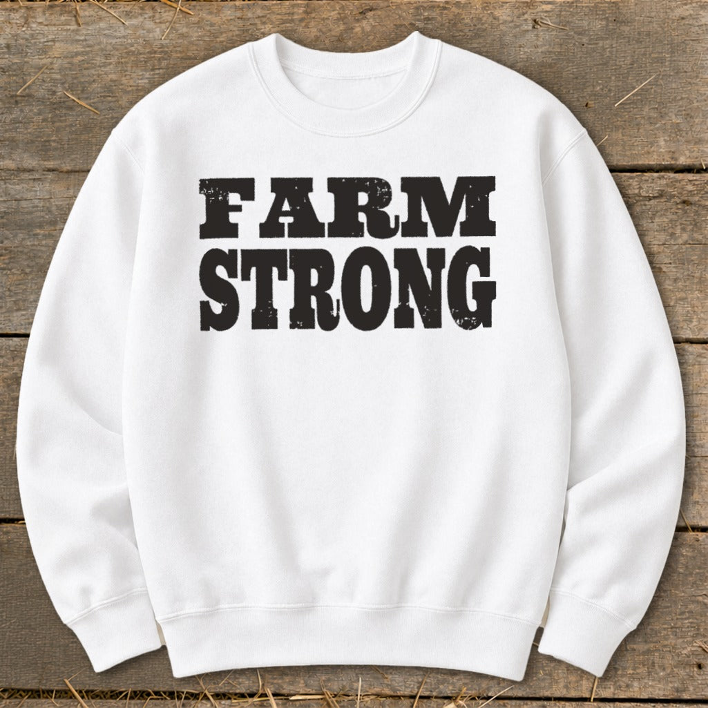 A white crewneck sweatshirt featuring the black distressed text FARM STRONG centered on the chest.
