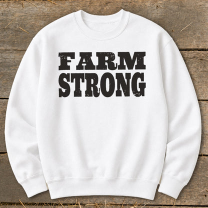 A white crewneck sweatshirt featuring the black distressed text FARM STRONG centered on the chest.