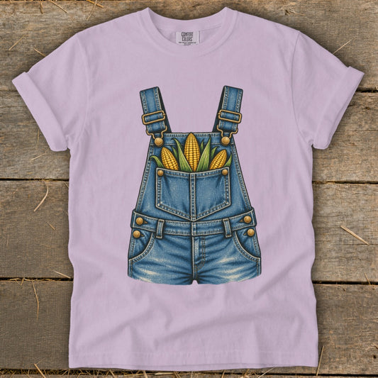 Light purple t-shirt with a graphic of denim overalls filled with corn.