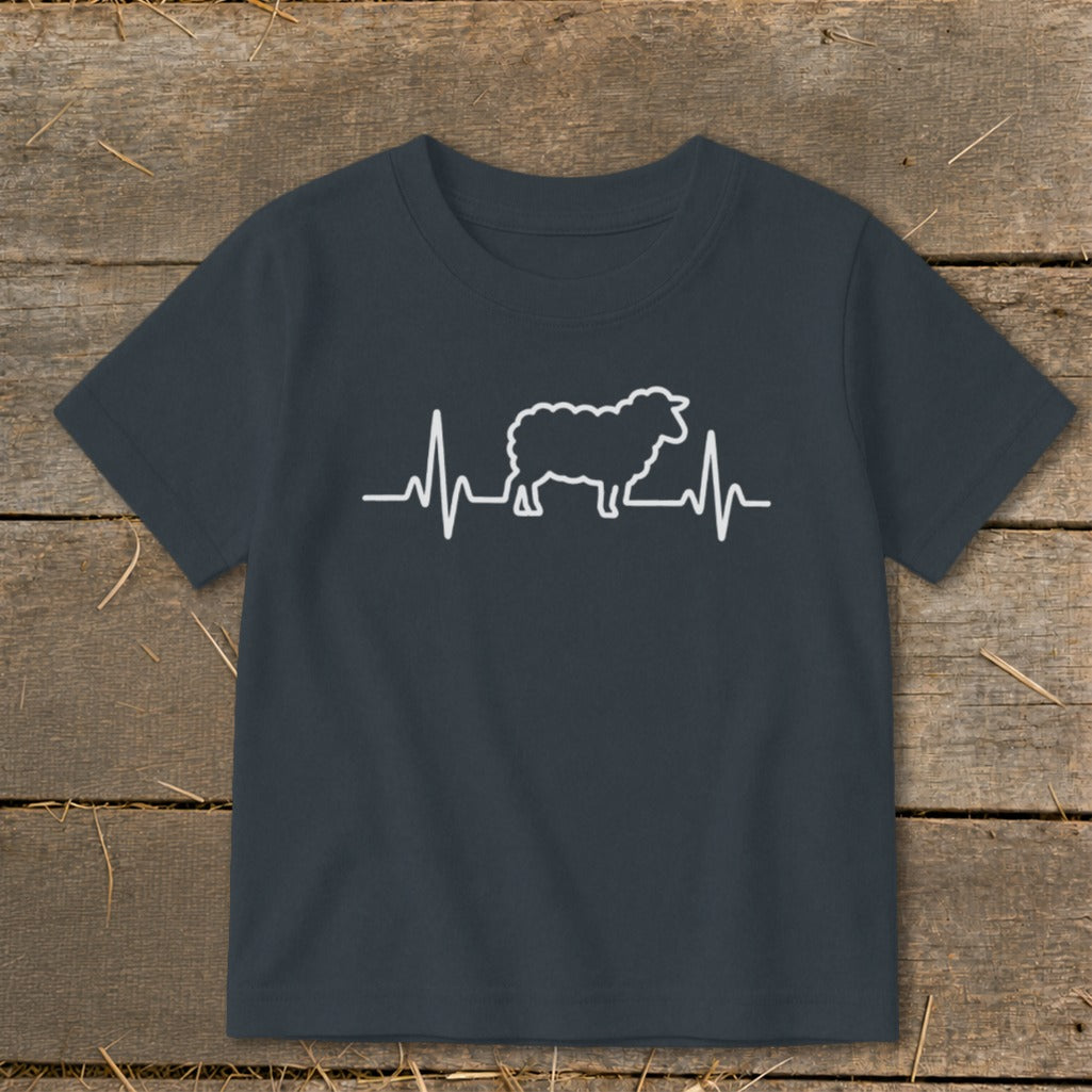 A dark gray children's t-shirt printed with a white graphic of a sheep overlaid on a heartbeat line.