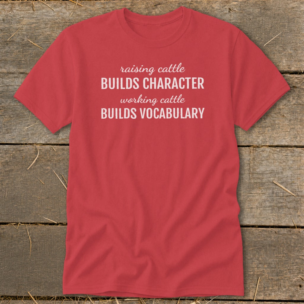 Red t-shirt with white text "raising cattle BUILDS CHARACTER working cattle BUILDS VOCABULARY".
