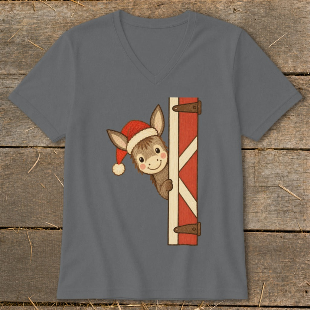 Donkey wearing Santa hat peeks from behind a red barn door on a grey v-neck t-shirt.