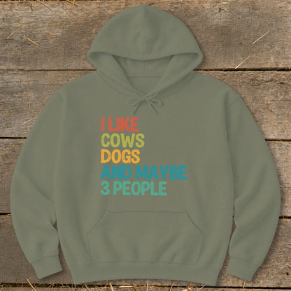 Olive green hoodie with vintage text "I LIKE COWS DOGS AND MAYBE 3 PEOPLE".
