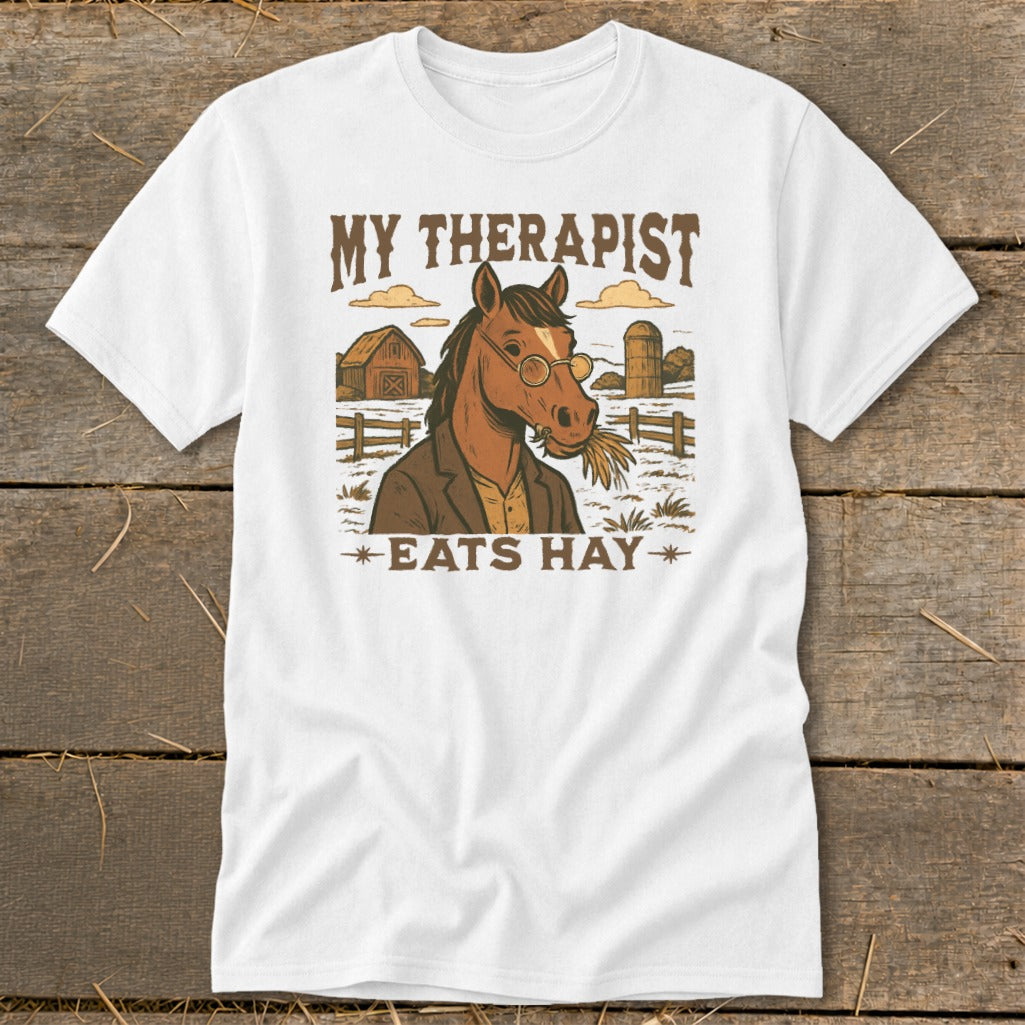 White t-shirt graphic of a horse in glasses with text "My therapist eats hay."