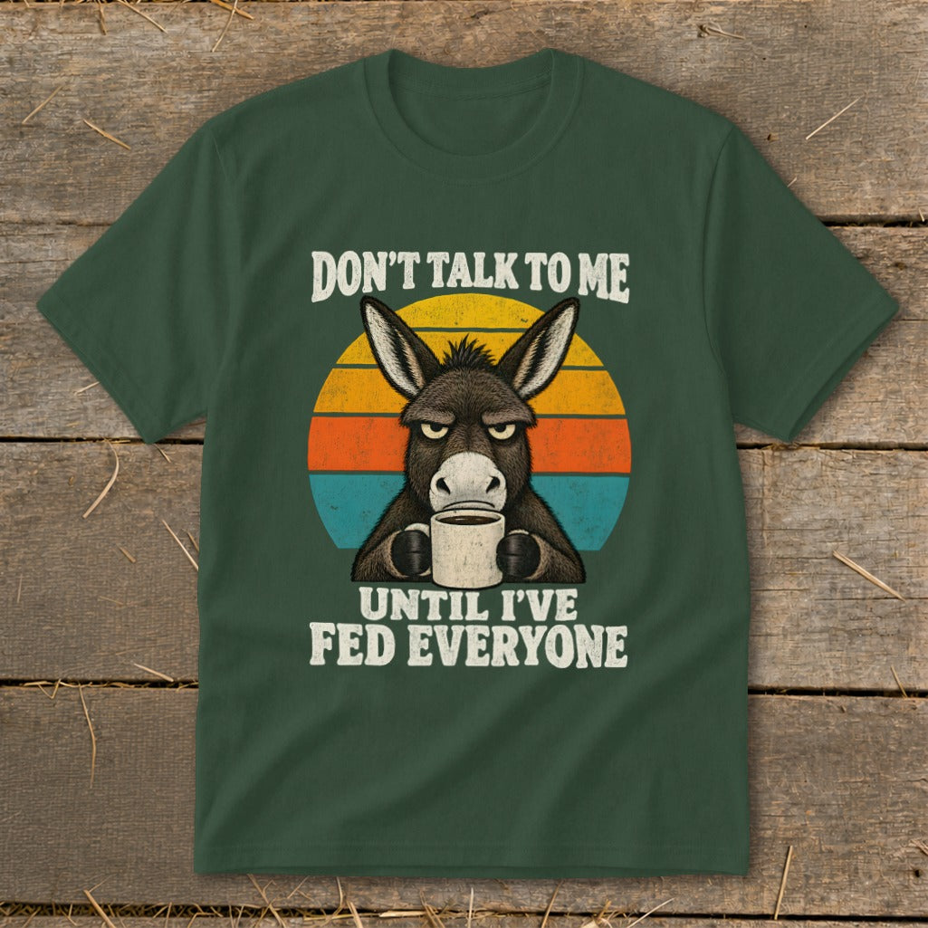 Dark green t-shirt featuring an angry donkey holding a coffee mug, surrounded by retro stripes and the text "DON'T TALK TO ME UNTIL I'VE FED EVERYONE."