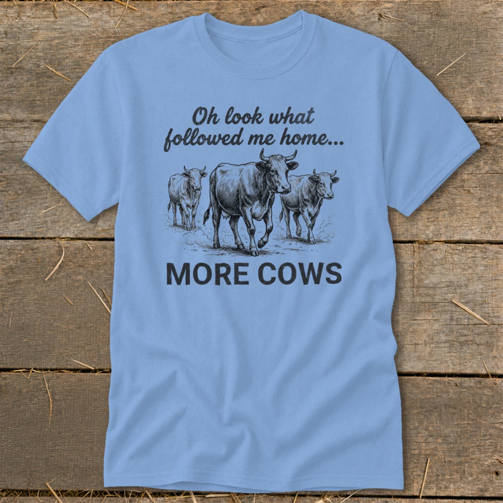 Light blue t-shirt with sketch of three cows and text "Oh look what followed me home... MORE COWS".