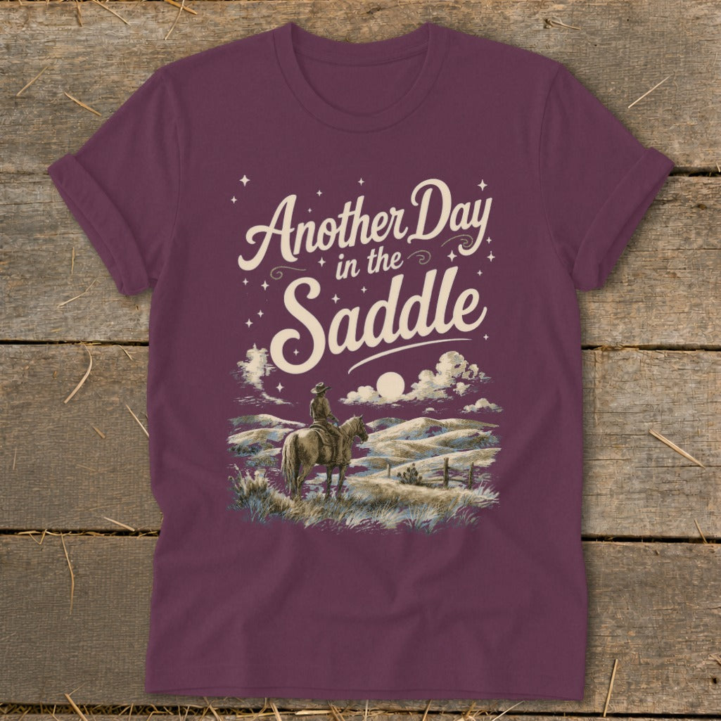 Maroon t-shirt with "Another Day in the Saddle" text and a cowboy on horseback.