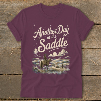 Maroon t-shirt with "Another Day in the Saddle" text and a cowboy on horseback.