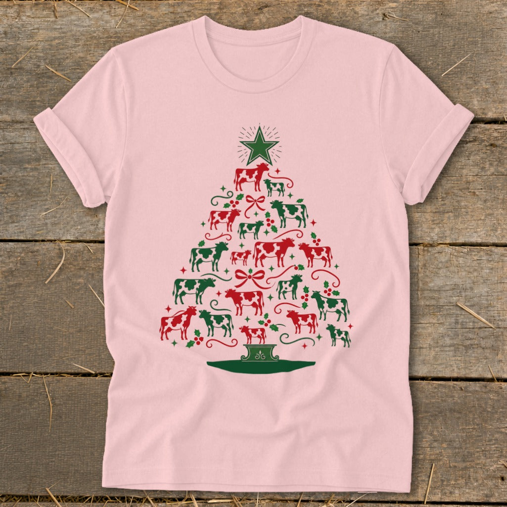 Pink t-shirt with a Christmas tree made of red and green cows and holly.