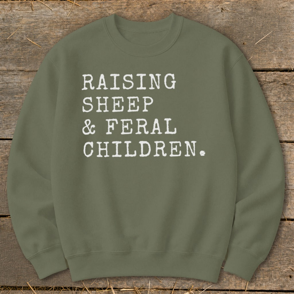 Olive green sweatshirt with white text: Raising Sheep & Feral Children.