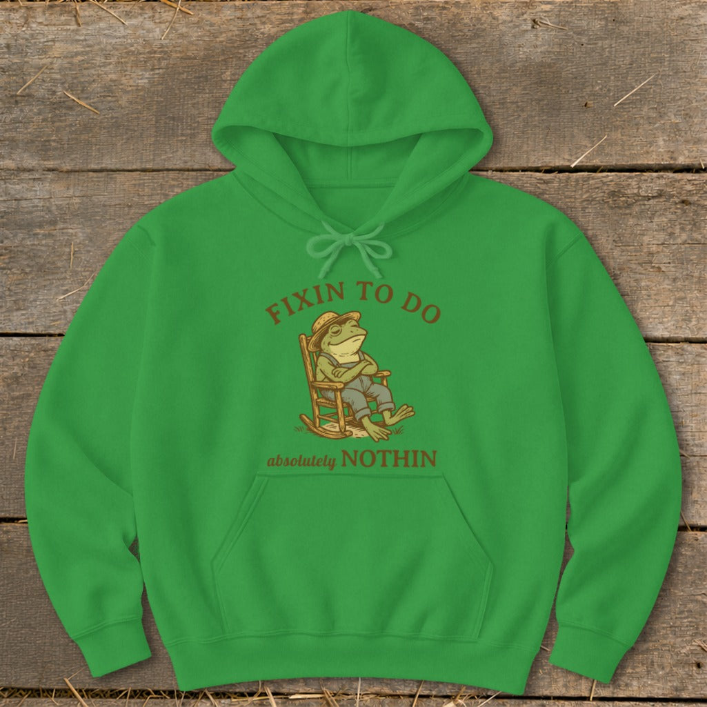 Green hoodie with a frog in a rocking chair and text "fixin to do absolutely nothin."