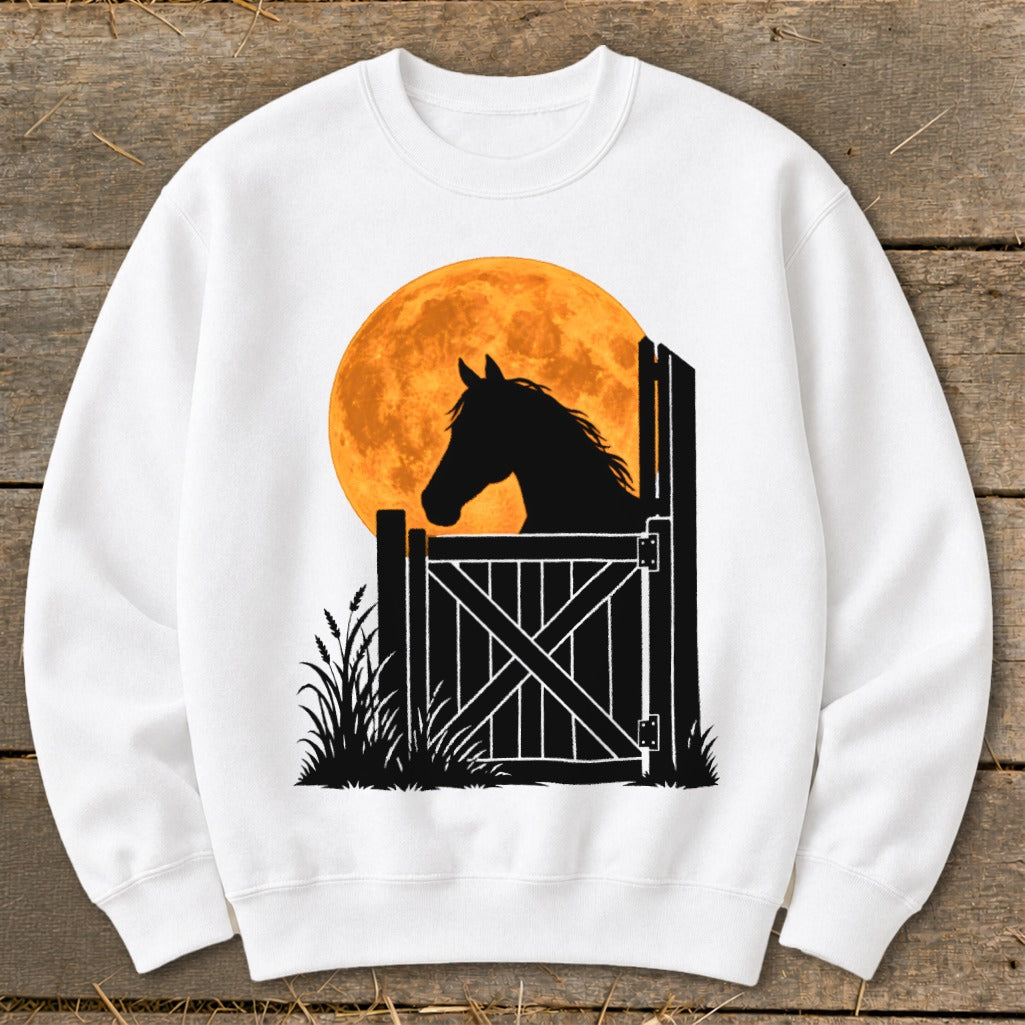 White crewneck sweatshirt featuring a black silhouette of a horse looking over a stable door against an orange full moon.