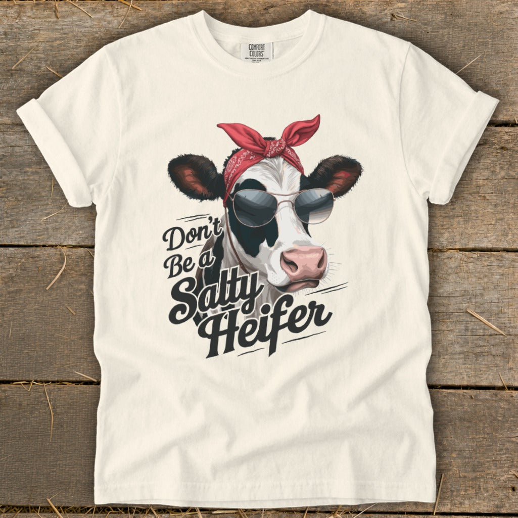 Cream t-shirt with a cow wearing sunglasses and a bandana with "Don't Be a Salty Heifer" text.
