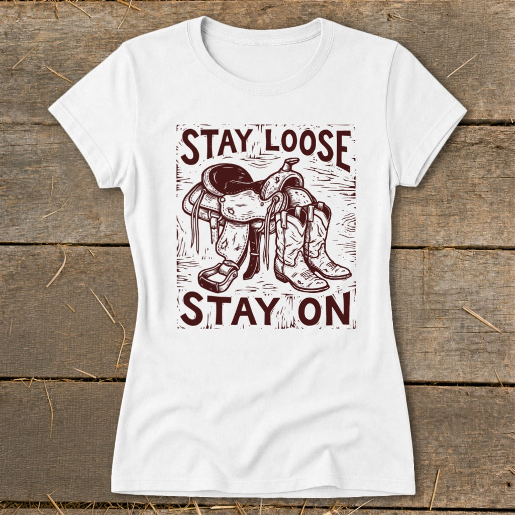 White t-shirt with "Stay Loose Stay On" text and cowboy saddle and boots graphic.