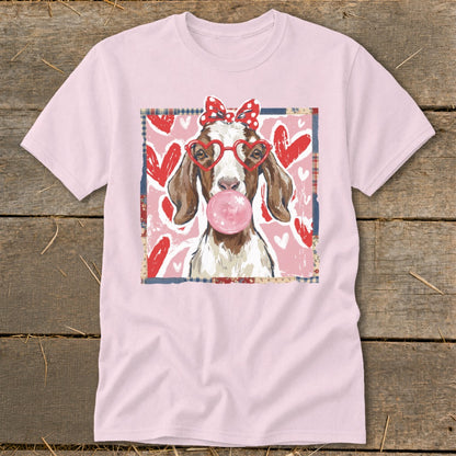 Light pink t-shirt with a graphic of a goat wearing a bow and heart glasses blowing bubblegum.